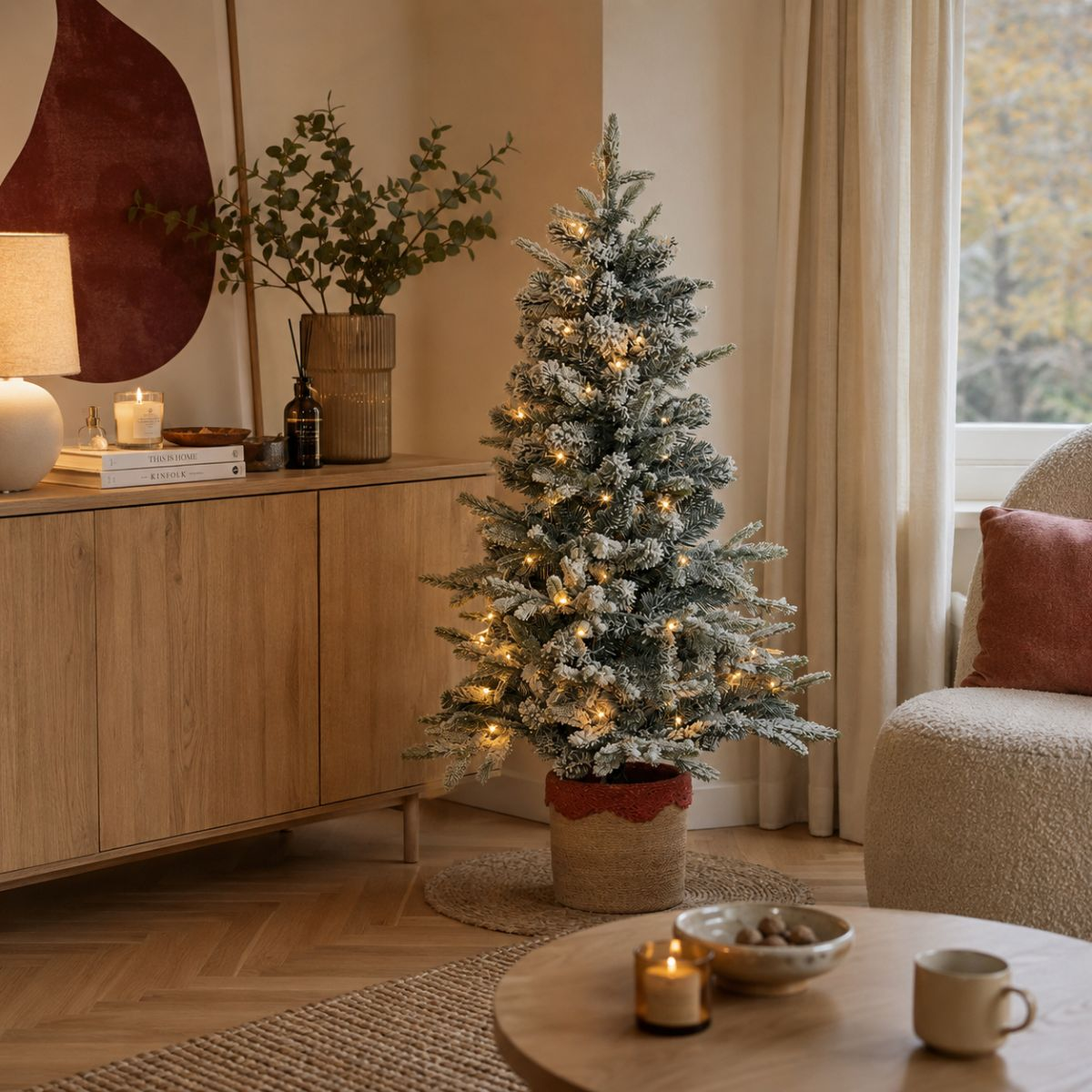 A decorated Christmas tree with lights stands in a cozy living room.