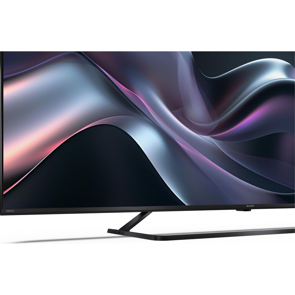 Une TV moderne à écran plat affichant un économiseur d'écran abstrait et ondulé aux teintes violettes et argentées.