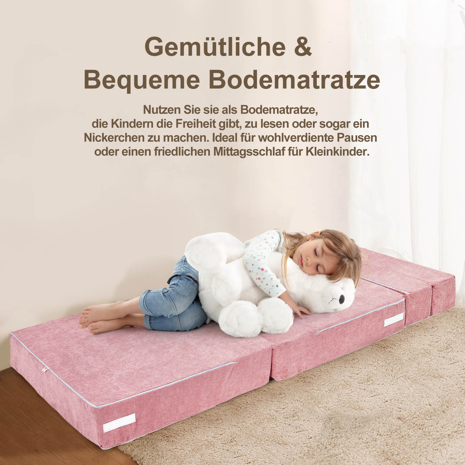 Ein kleines Mädchen schläft auf einer rosafarbenen Bodamatratze mit einem Teddybär.