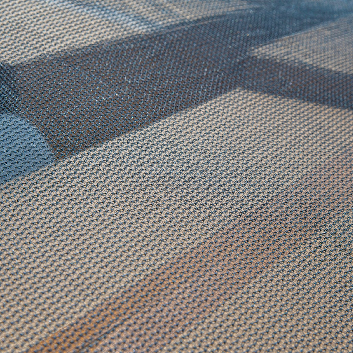 Close-up van donkerblauw mesh met schaduwstrepen.
