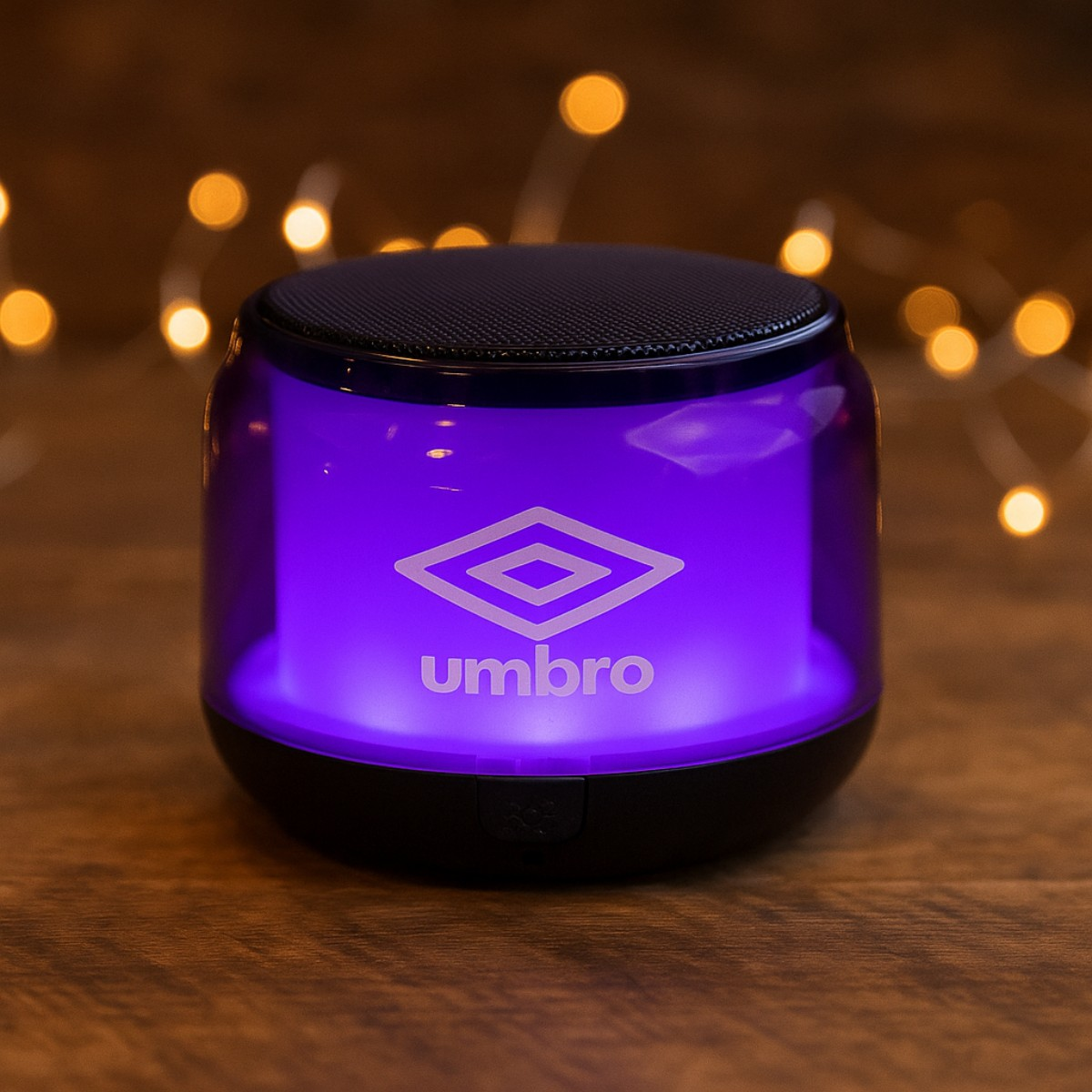A purple Umbro speaker with lights in the background.