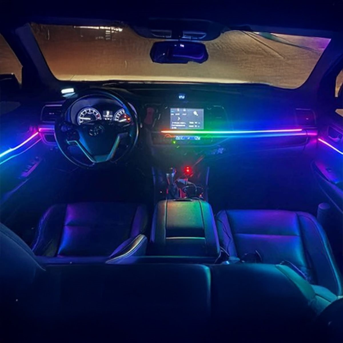 Auto-interieur met kleurrijke sfeerverlichting, dashboard en stoelen.