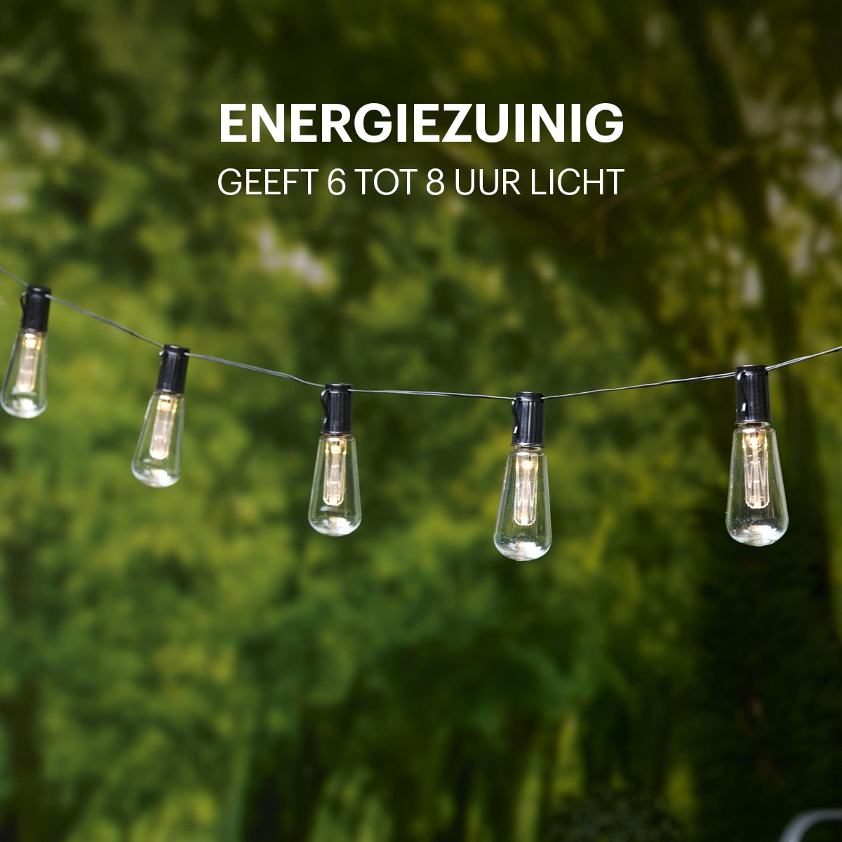 Een lichtsnoer met lampen hangt voor groen gebladerte. Energiezuinig 6-8 uur.