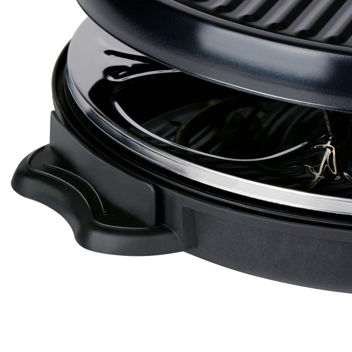 Close-up van een zwarte grill met zilveren rand en verwarmingselement.