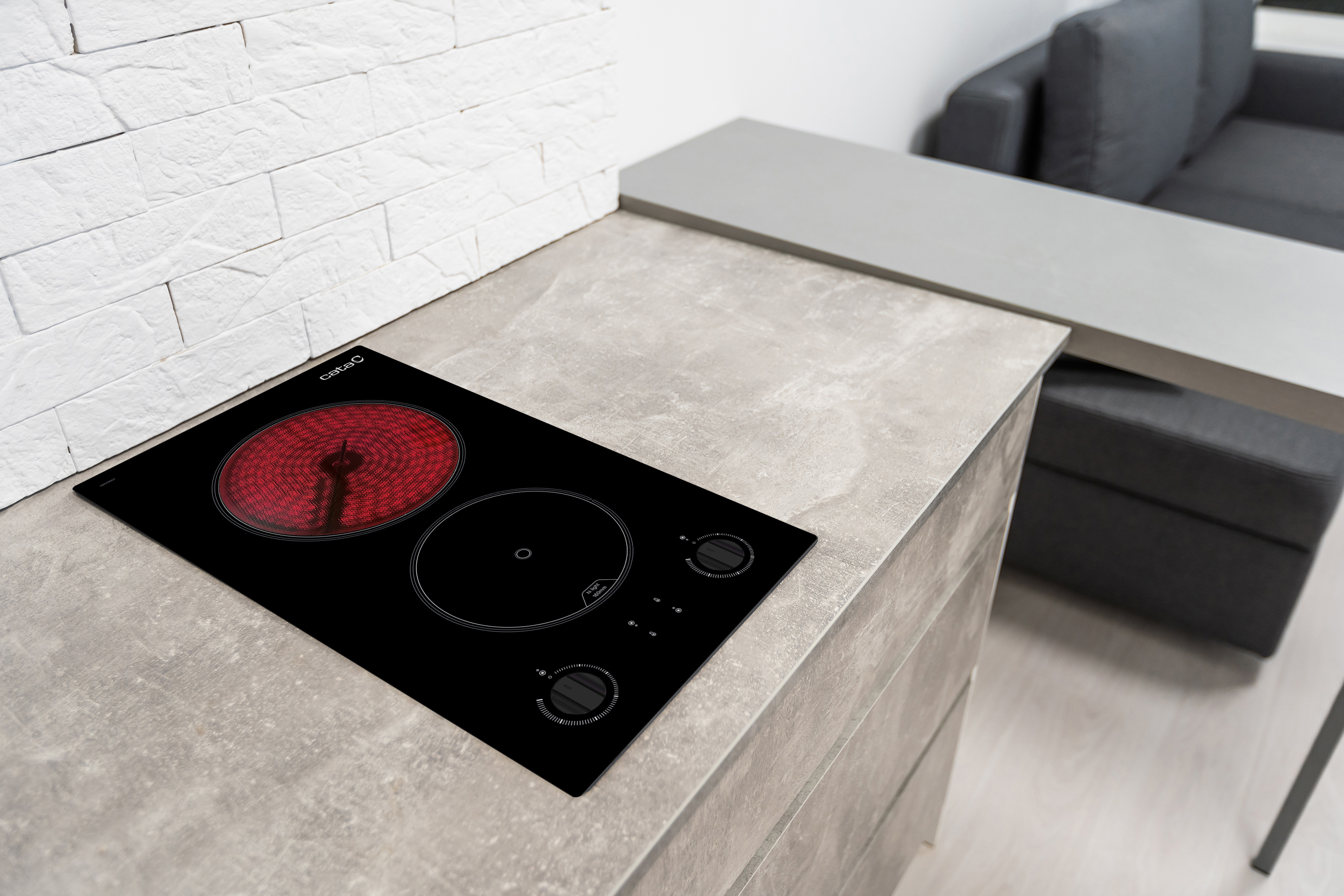 Piano cottura in vetroceramica nero con elemento riscaldante rosso.