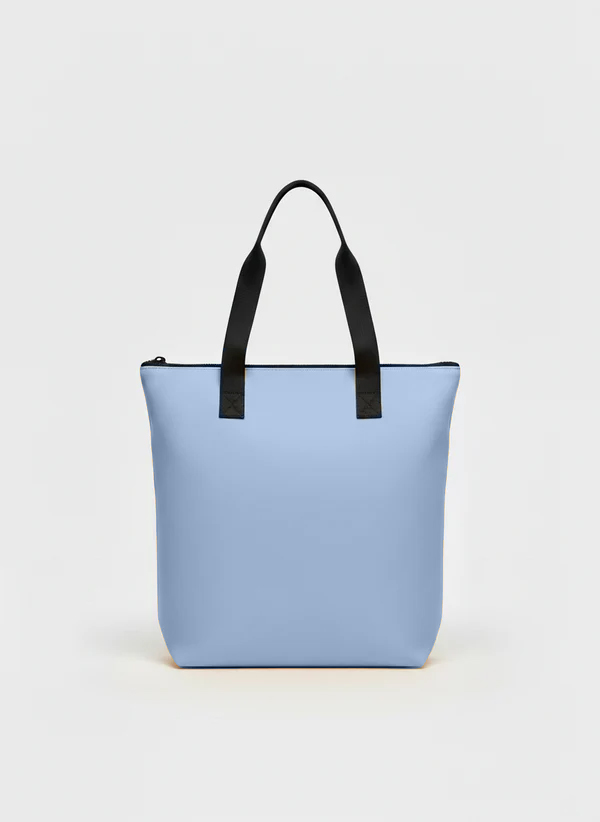 Una borsa tote azzurra con manici neri e cerniera nera, centrata su uno sfondo bianco semplice.