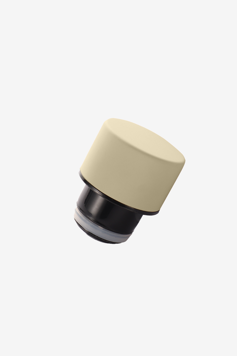 Un tappo bottiglia beige con inserto e guarnizione neri