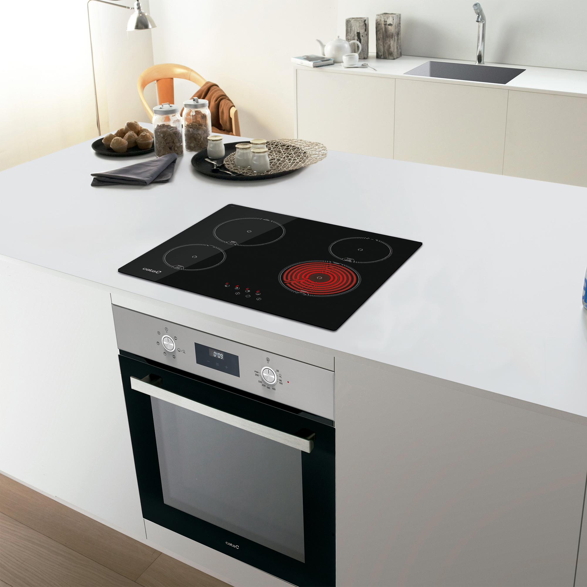 Un'isola cucina moderna con piano cottura elettrico nero e forno da incasso.