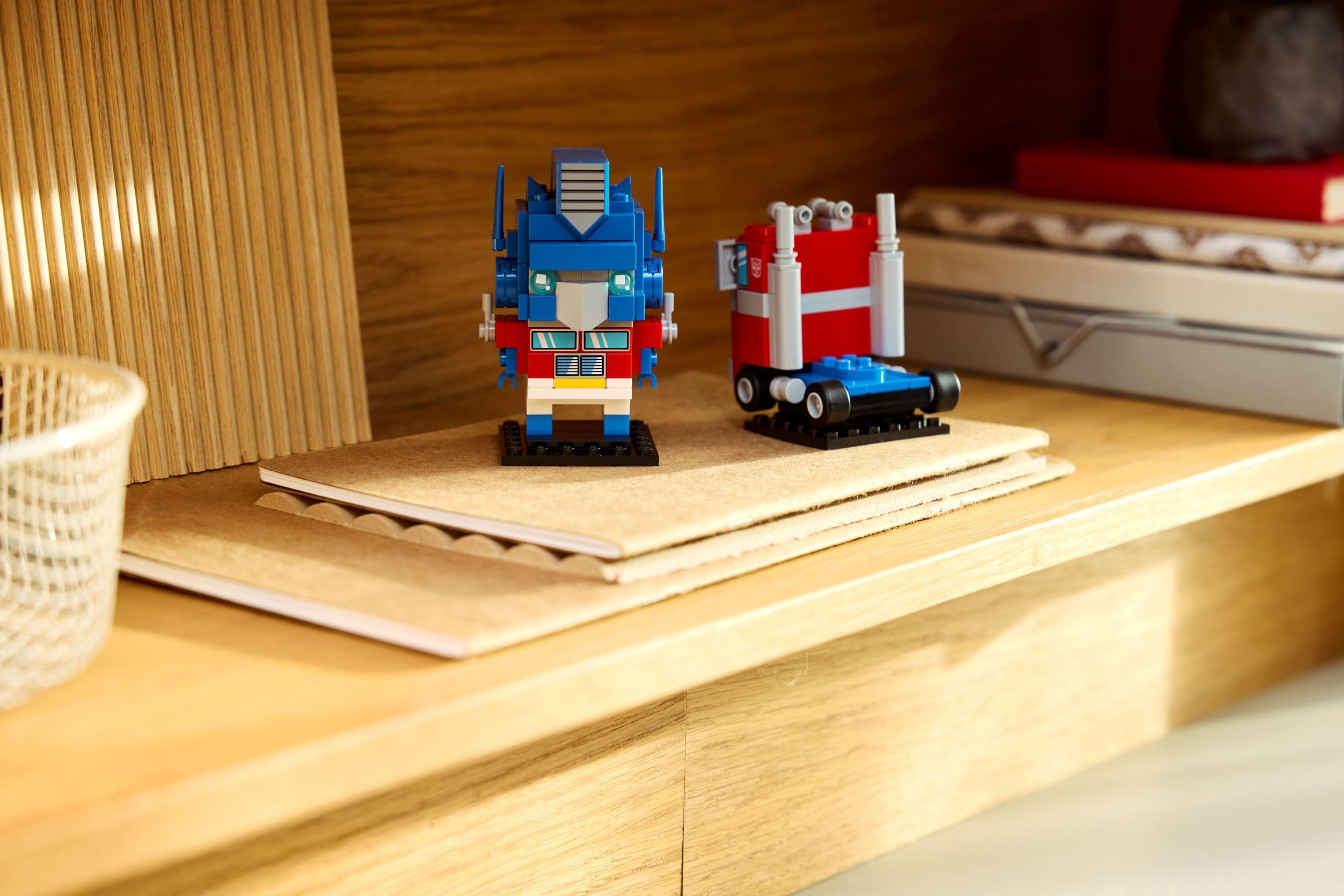 Optimus Prime ve kamyon Lego figürleri defterlerin üzerinde duruyor.