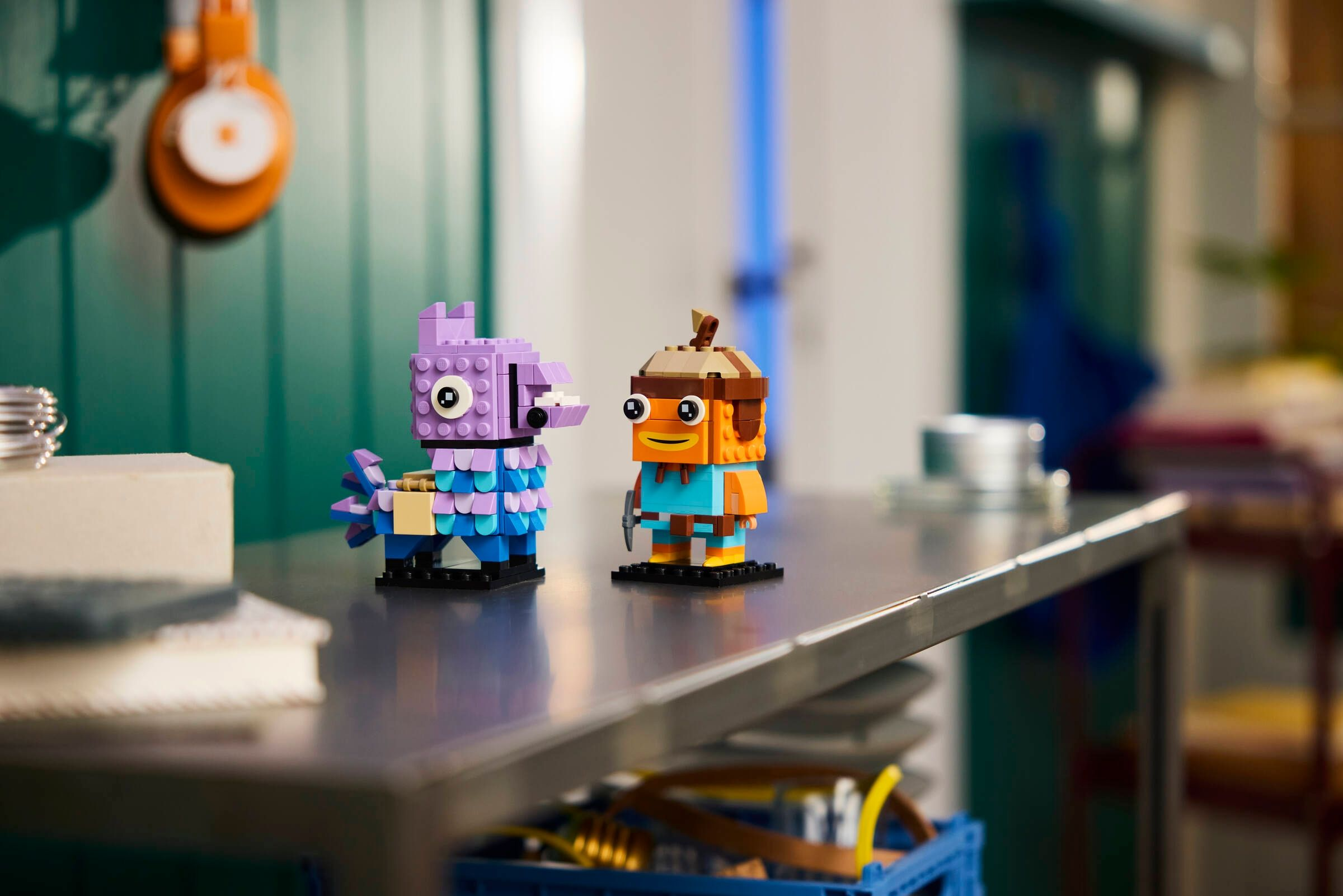 İki renkli Lego figürü: mor bir lama ve turuncu balık karakter.