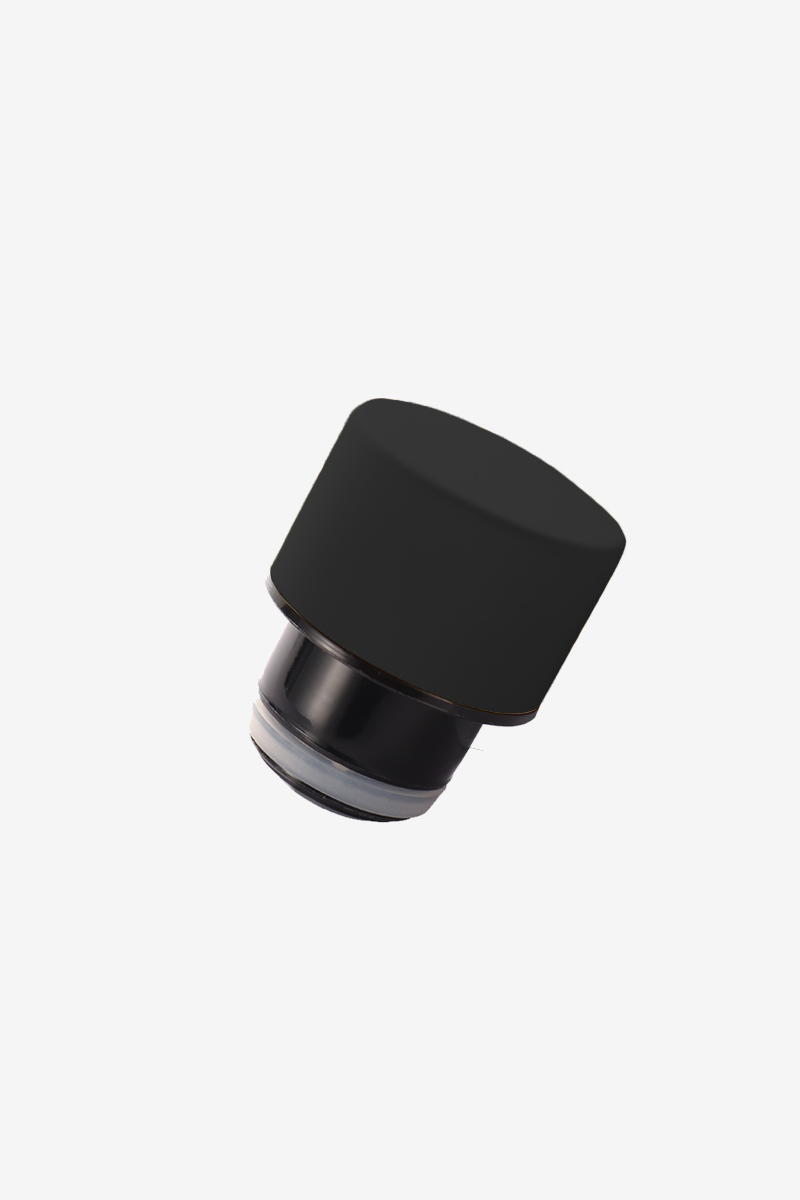 Un tappo di bottiglia nero con un anello argentato su sfondo bianco.