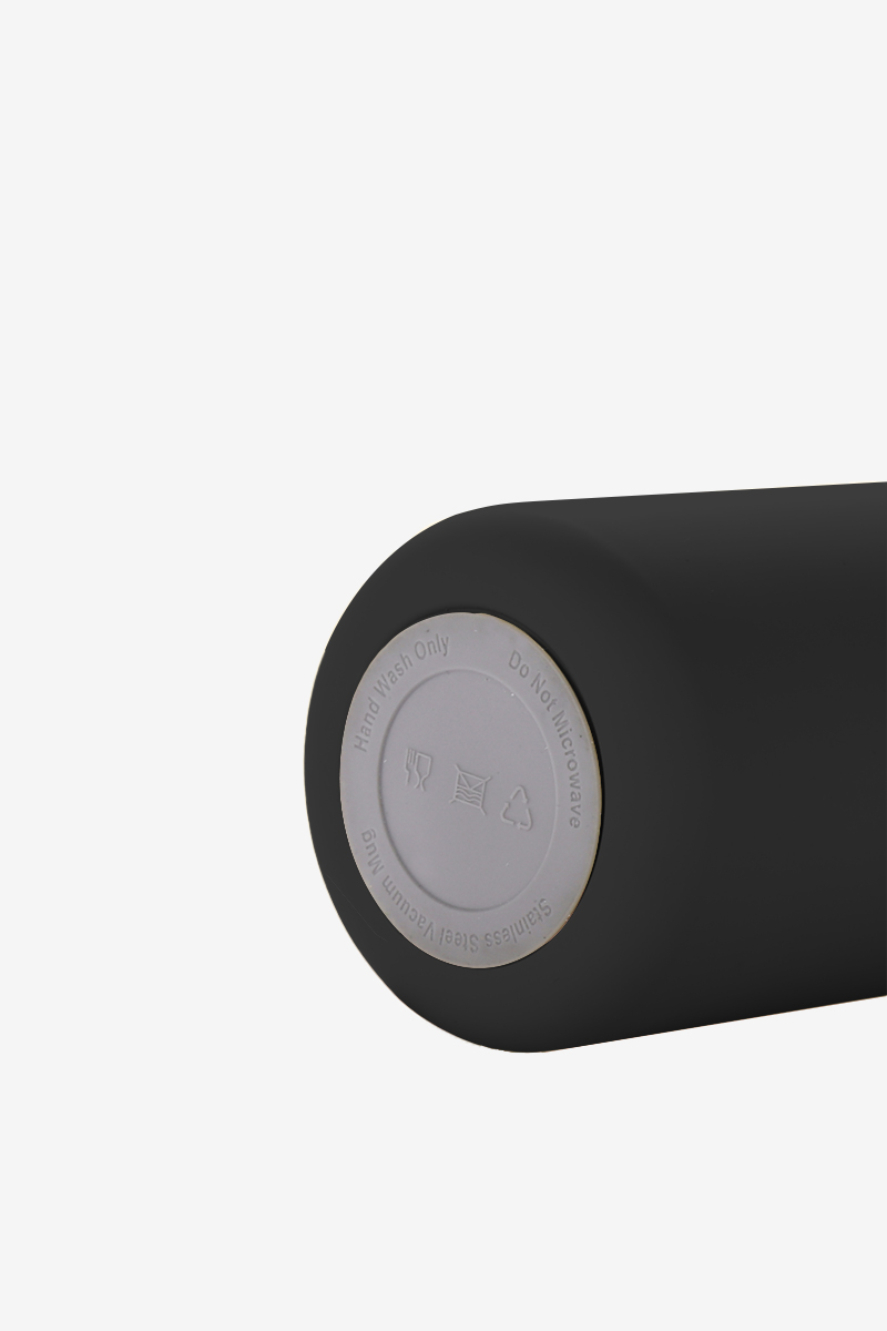 Fondo di una tazza nera che mostra istruzioni per la cura e materiali.