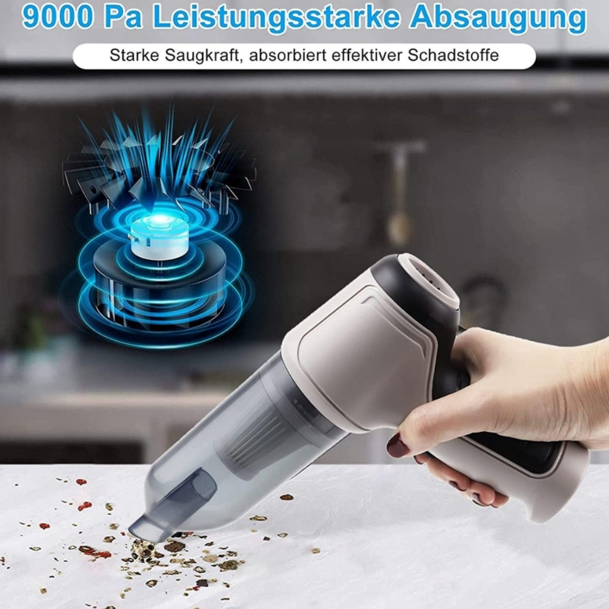 Eine Hand hält einen grauen Akku-Staubsauger, der Krümel aufsaugt.