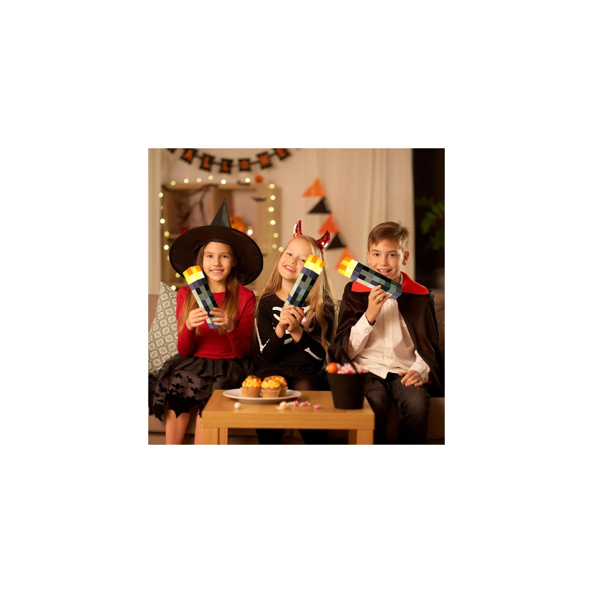 Drei Kinder in Kostümen halten Fackeln. Im Hintergrund Halloween-Deko.