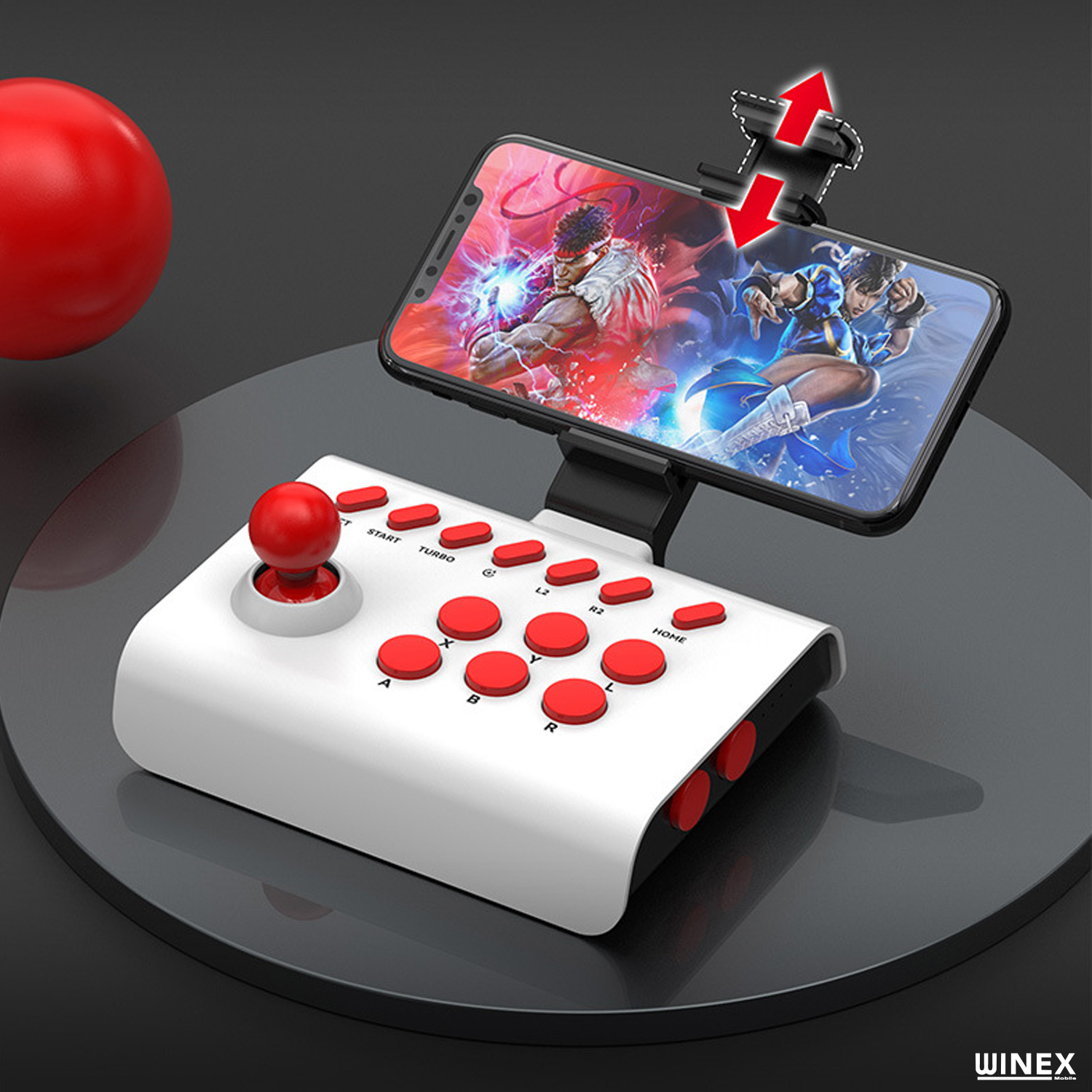Kırmızı düğmeli beyaz arcade joystick, dövüş oyunu gösteren bir telefon tutuyor.