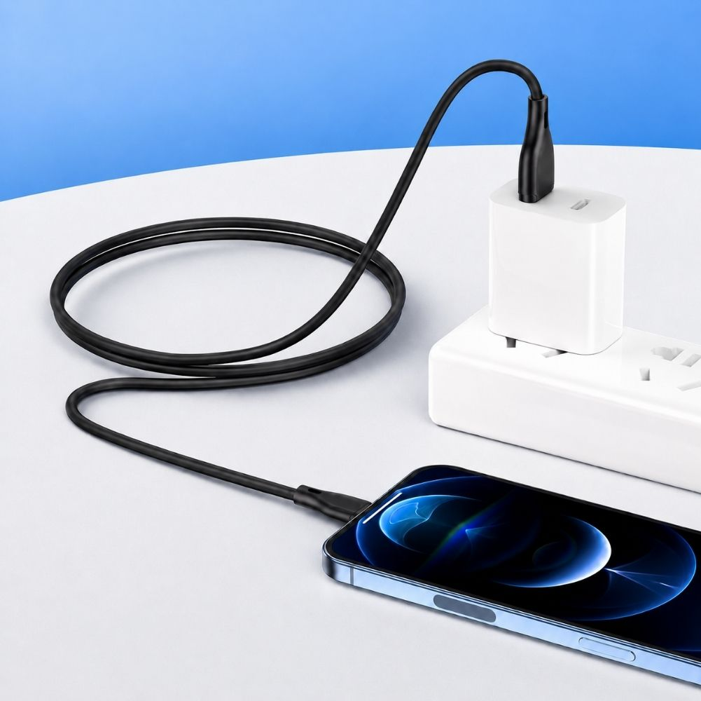 Siyah bir şarj kablosu, prizdeki beyaz bir güç adaptörüne bir akıllı telefon bağlar.