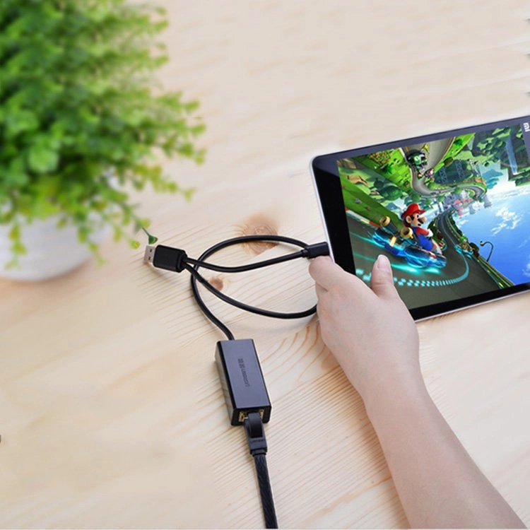 Una mano tiene un tablet che mostra un gioco di Mario Kart. Un cavo USB è collegato.