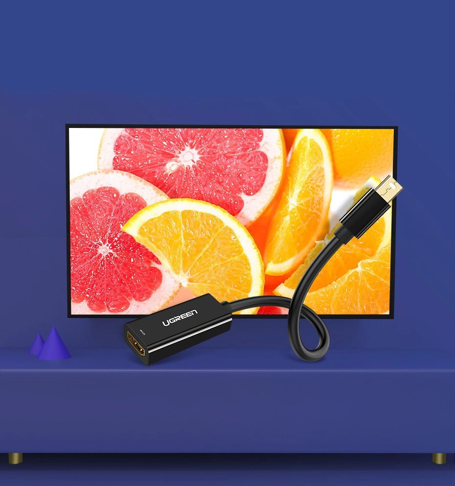Un cavo adattatore UGREEN nero si collega a una TV che mostra fette di pompelmo e arance.
