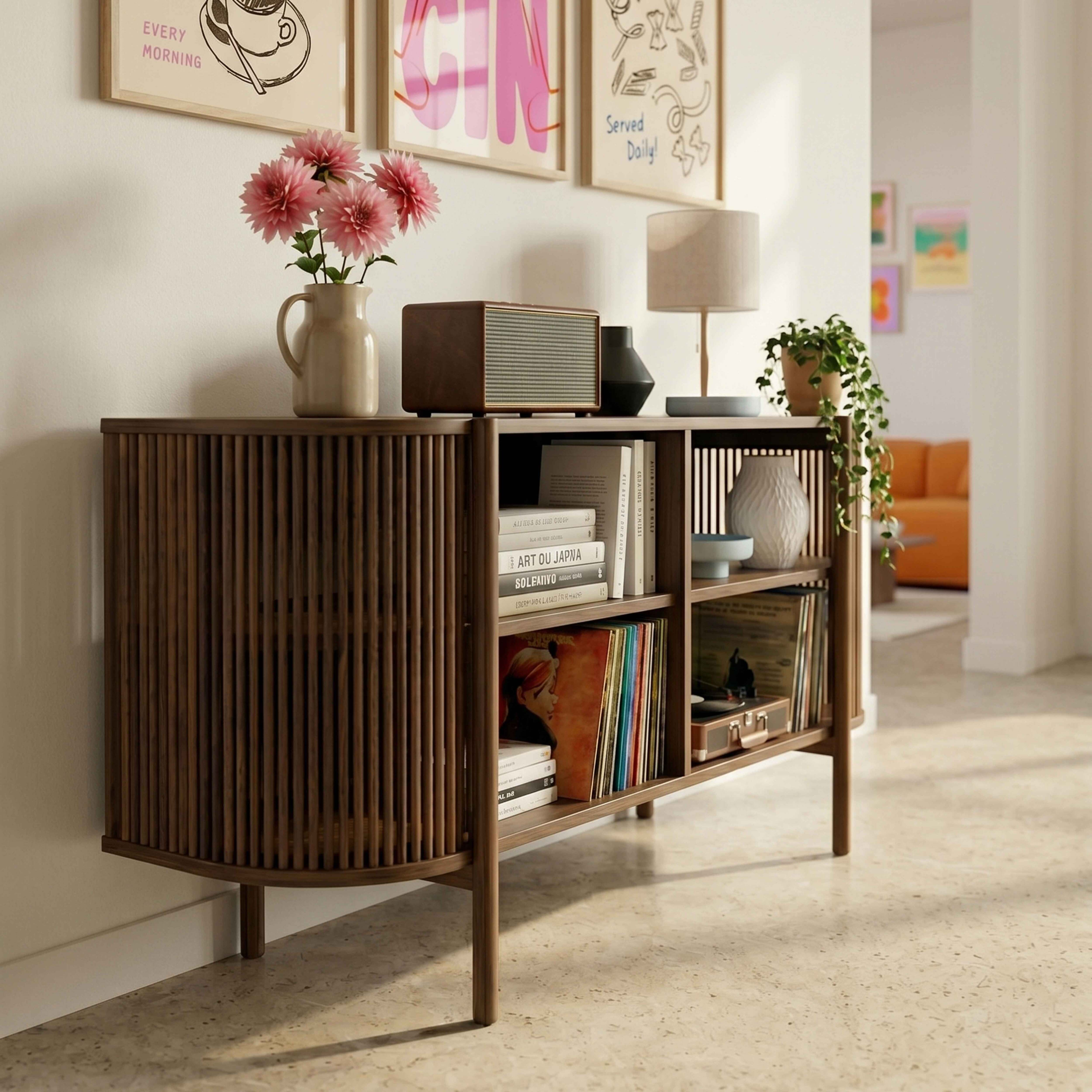Ein braunes Sideboard mit Büchern, Schallplatten und Dekoartikeln. Darüber Bilder.