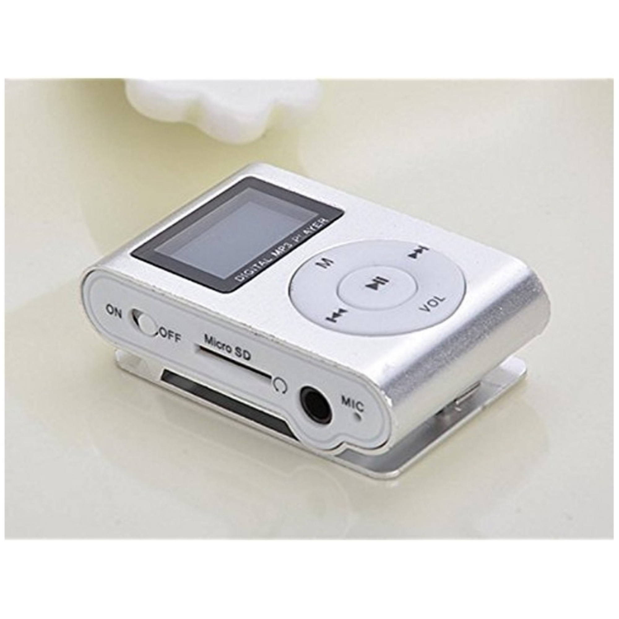 Kleiner silberner MP3-Player mit Bildschirm, Tasten und Anschlüssen auf glatter Oberfläche.