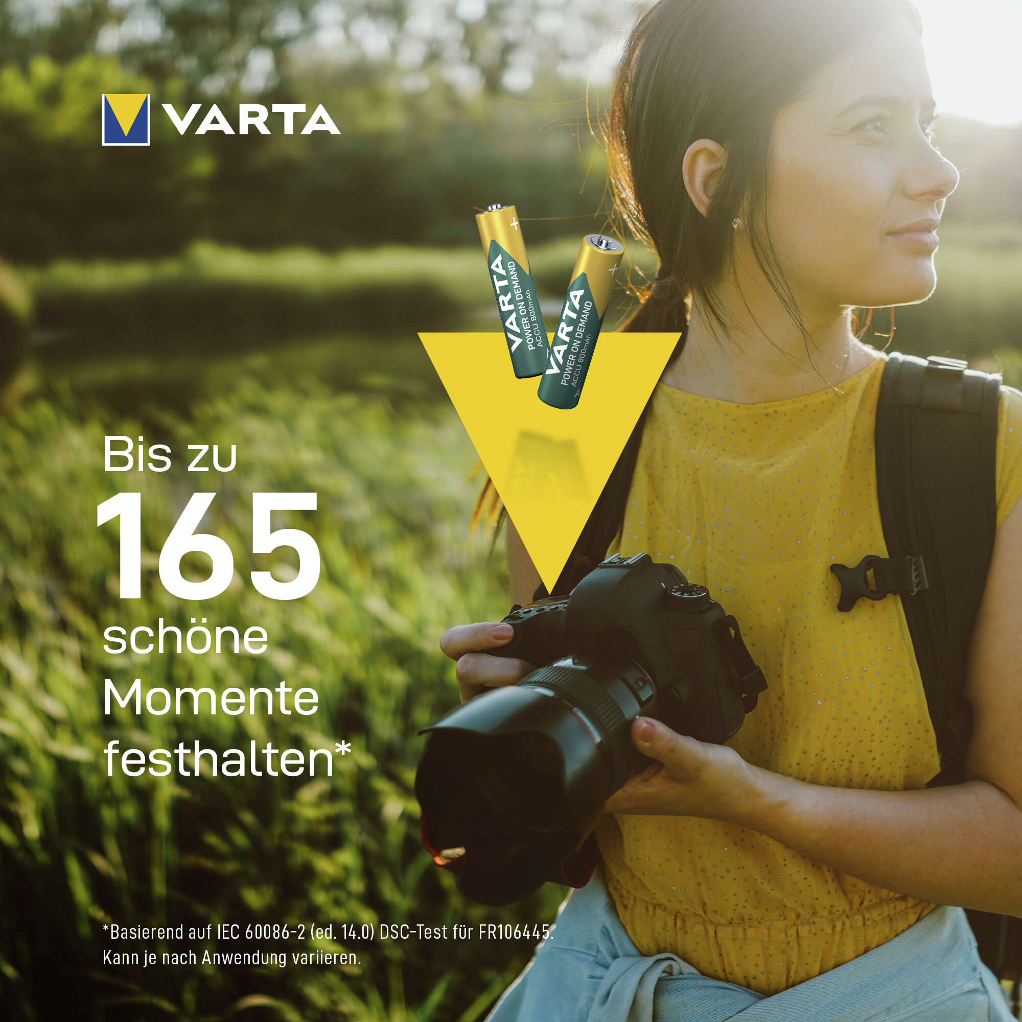 Frau mit Kamera und Varta-Batterien, im Freien, mit Text.