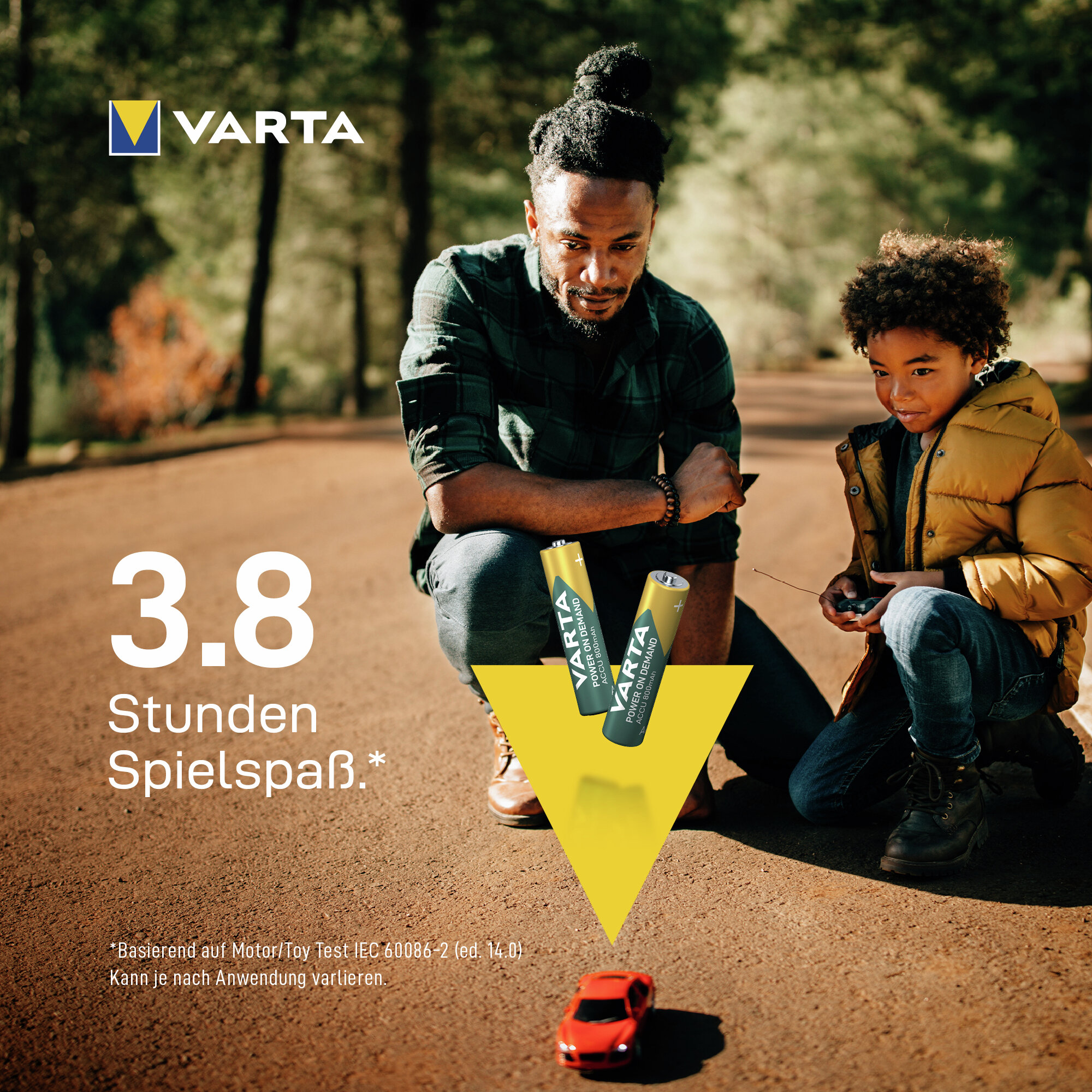 Mann und Kind spielen mit ferngesteuertem Auto, Varta Batterien.