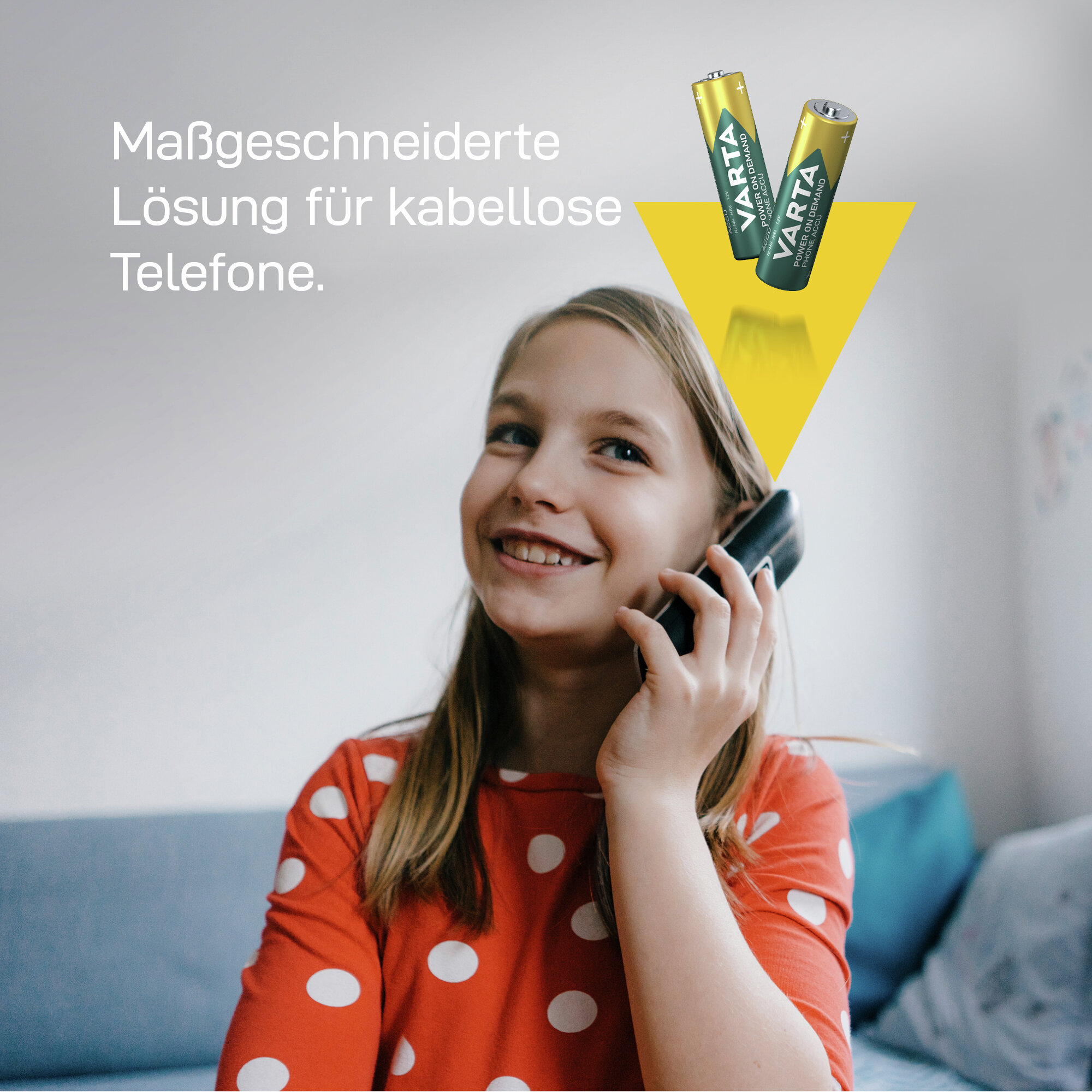 Mädchen telefoniert mit Schnurlostelefon; Varta Akkus im Hintergrund.