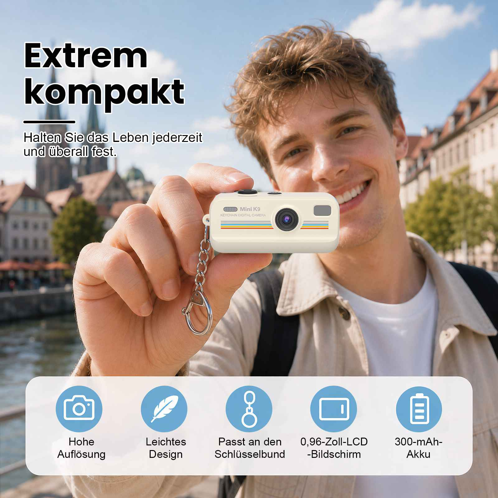 Mann hält eine Mini-Kamera am Schlüsselbund. Hintergrund mit Gebäuden.