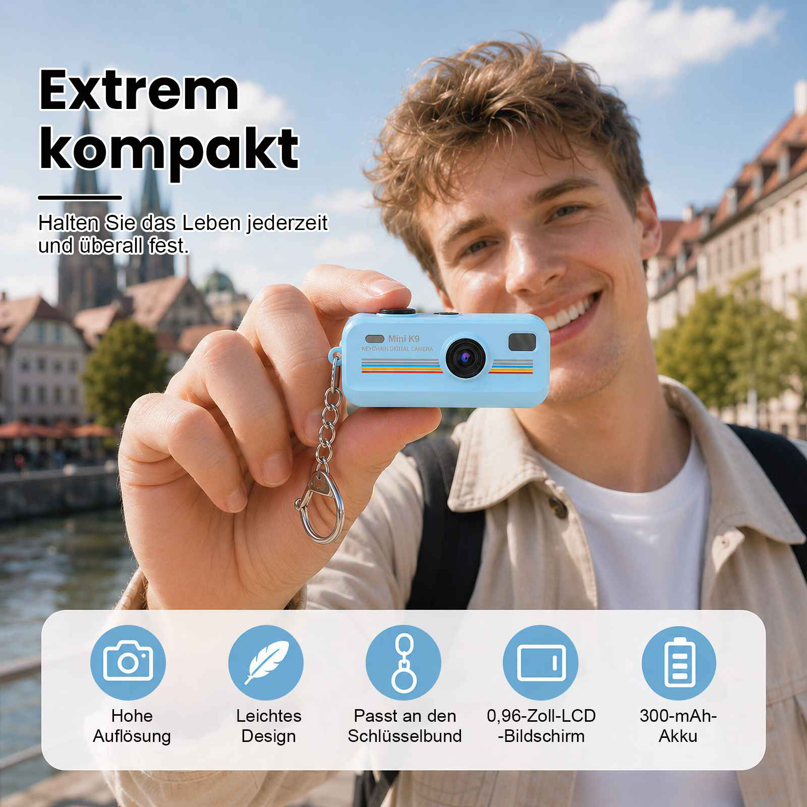 Ein Mann hält eine hellblaue Mini-Kamera mit Schlüsselanhänger. Hintergrund: Stadt.