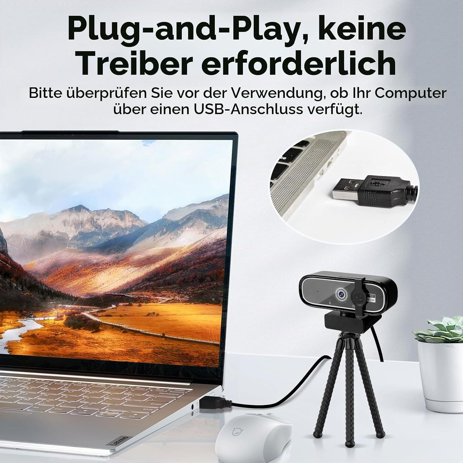 Laptop mit Webcam, Maus und USB-Kabel auf einem Schreibtisch.
