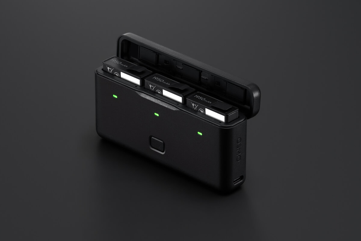 Ein schwarzes Osmo-Akkuladegerät mit drei 1950mAh-Akkus. Drei grüne Kontrollleuchten sind sichtbar.