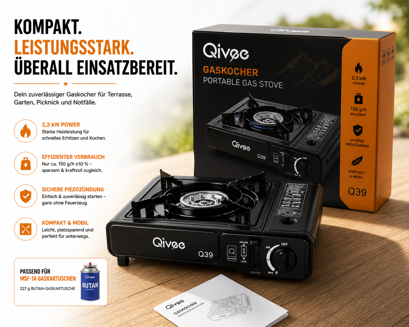 Ein schwarzer Gaskocher mit Zubehör und Beschriftung steht auf einem Holztisch.