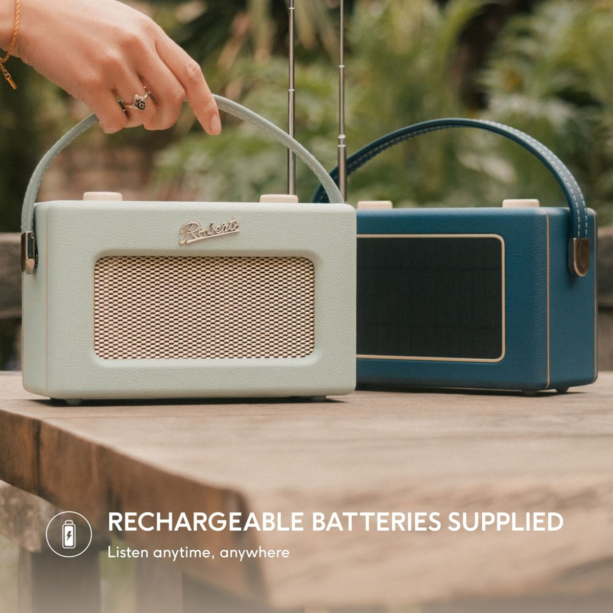 Zwei Retro-Radios, eines hellgrün, das andere blau, stehen auf einem Holztisch.
