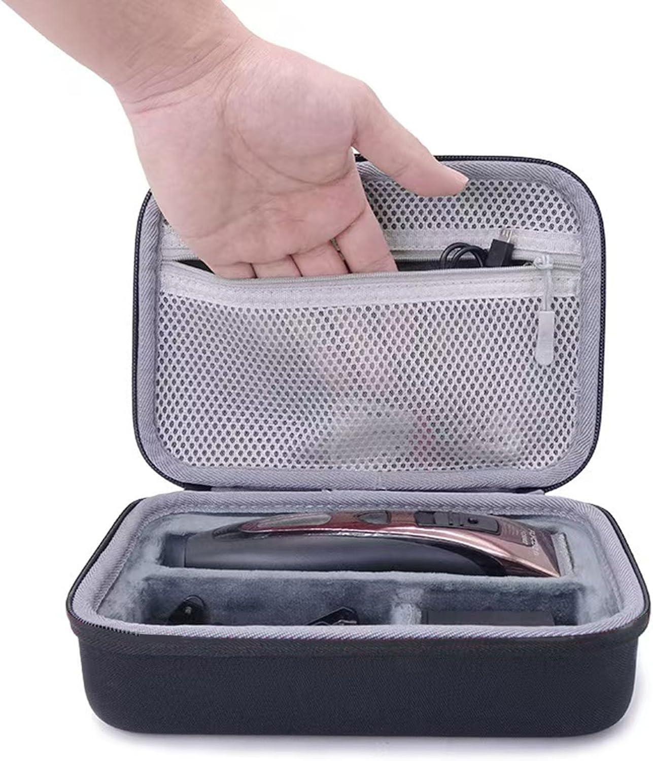Ein Mann legt ein Ladegerät in eine schwarze Reisetasche für einen Haarschneider.