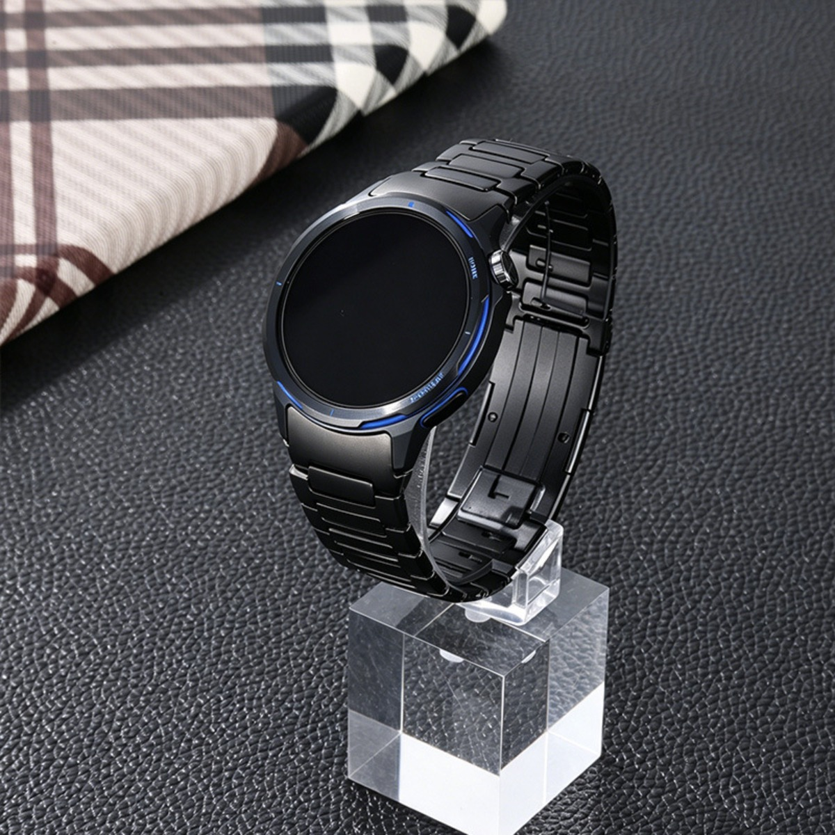 Eine schwarze Smartwatch mit blauem Akzent auf einem transparenten Ständer.