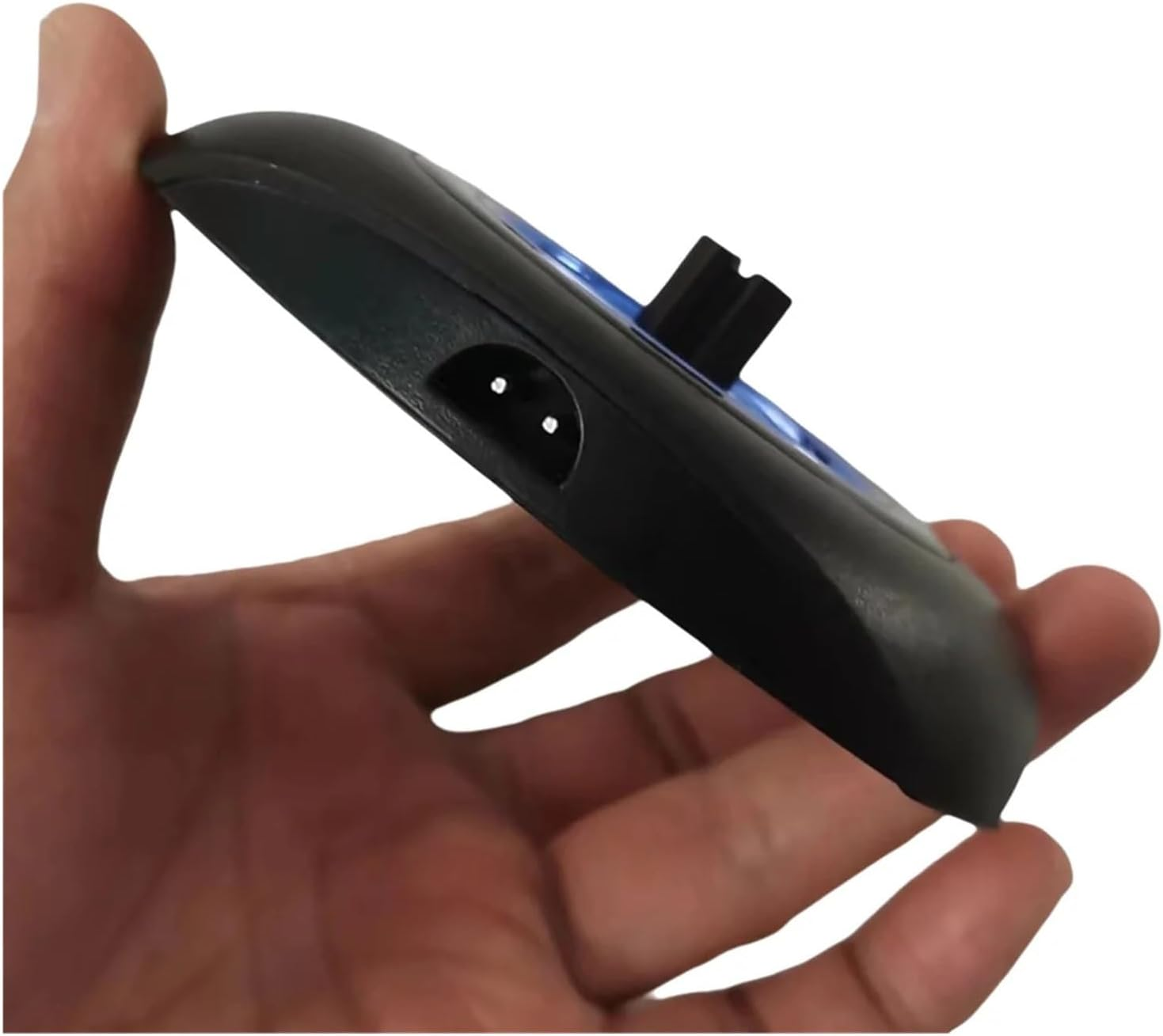 Eine Hand hält ein schwarzes elektronisches Gerät mit einem Stecker und blauen Lichtern.