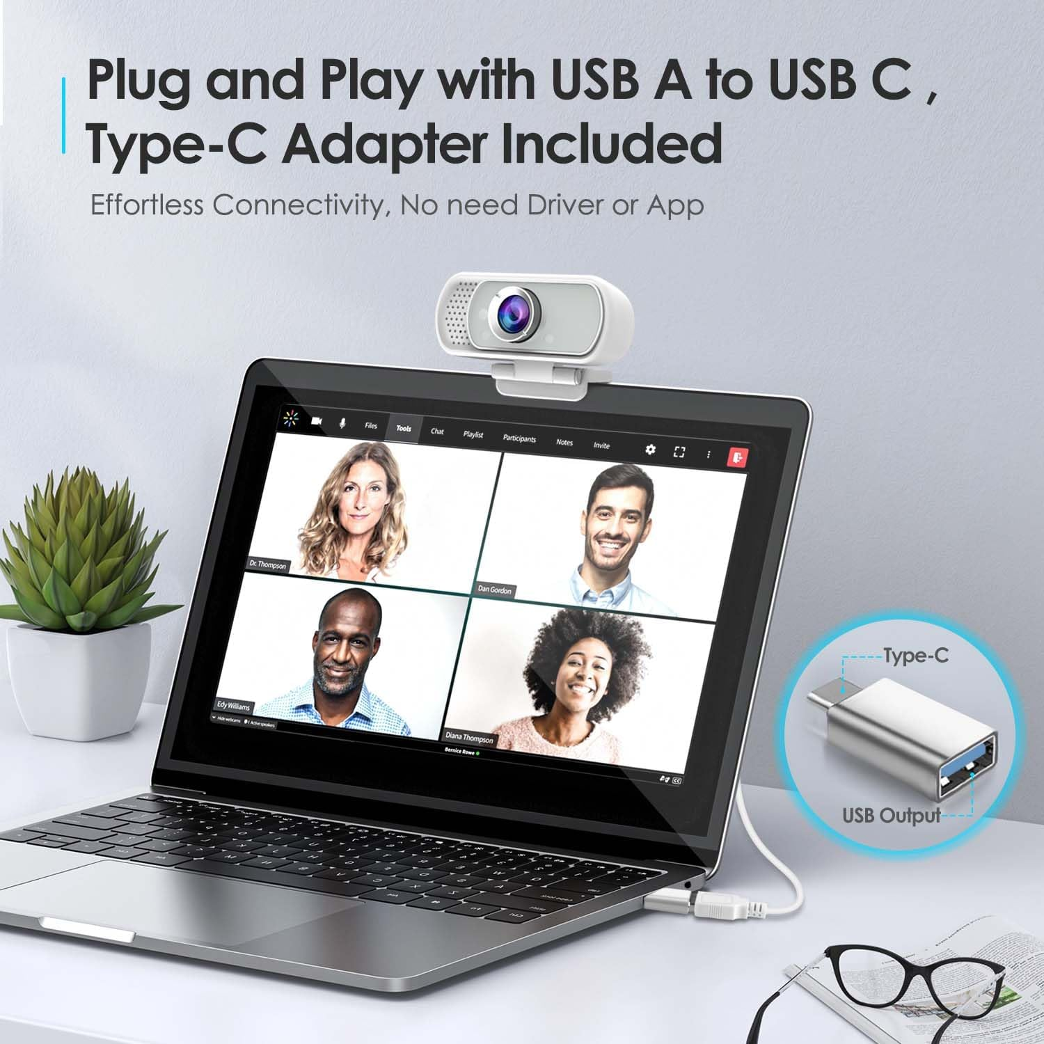 Laptop mit Webcam zeigt Videokonferenz. USB-C-Adapter daneben.