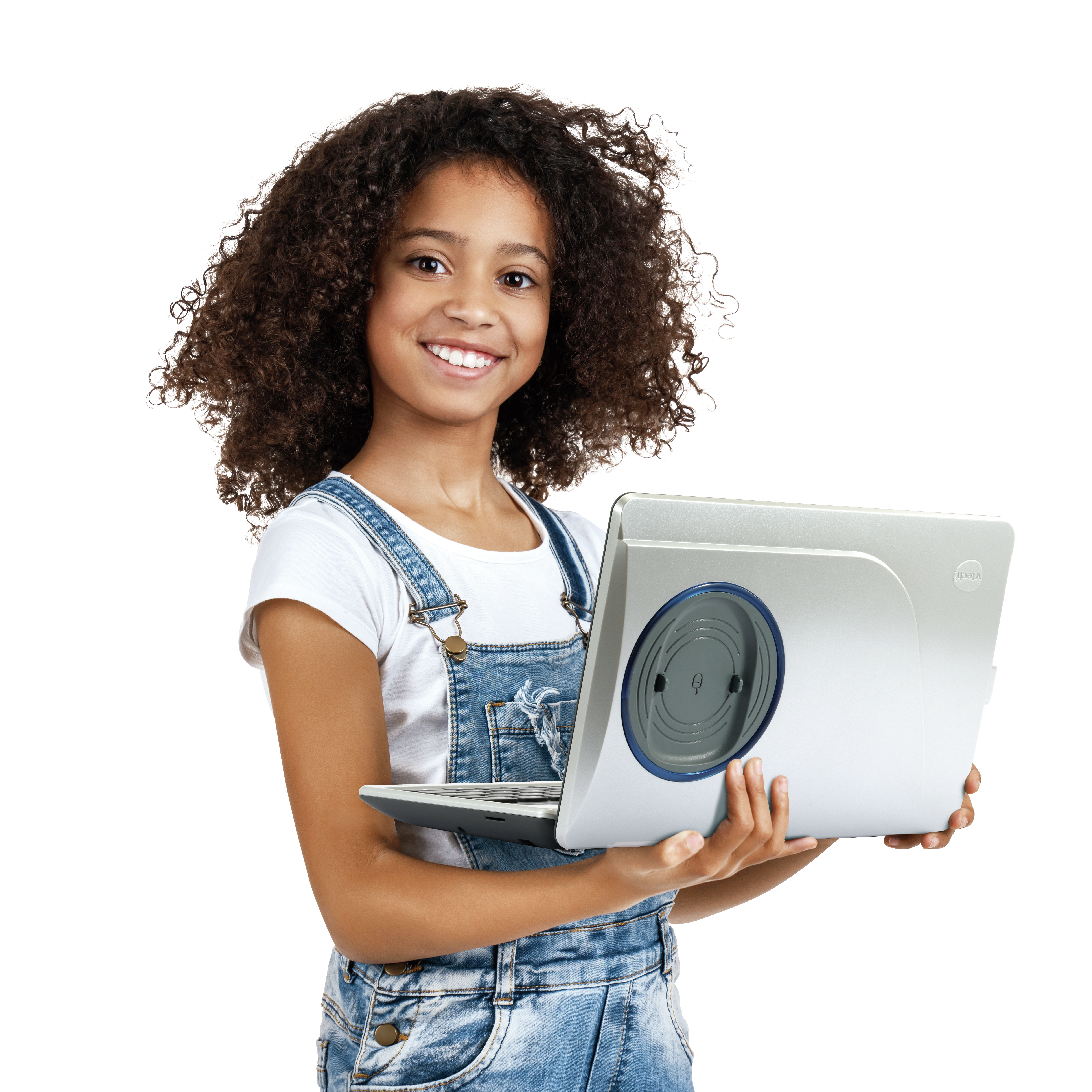 Ein junges Mädchen mit lockigem Haar trägt Latzhosen und ein weißes T-Shirt und hält einen Laptop.