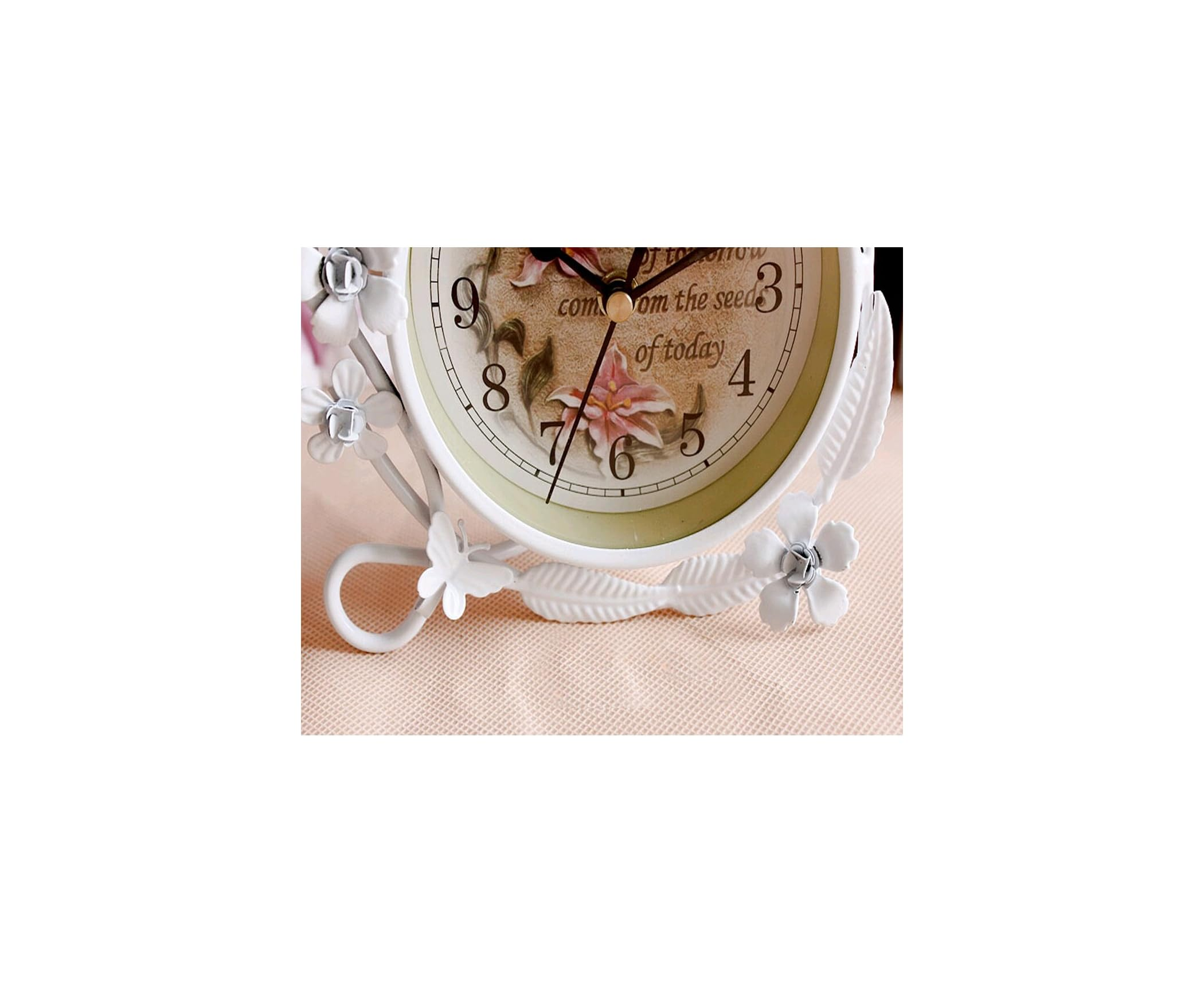 Eine weiße Uhr mit Blumenornamenten und der Aufschrift 'of today'.