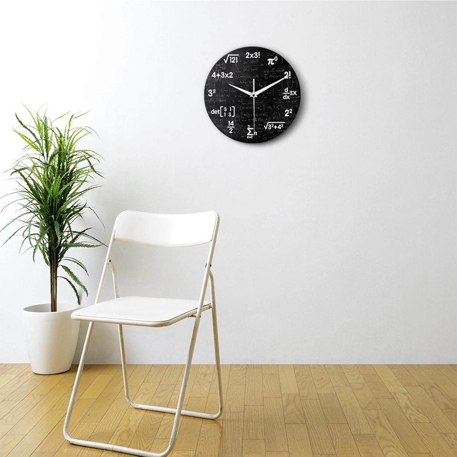 Eine schwarze Wanduhr mit mathematischen Formeln, daneben ein weißer Stuhl und eine Pflanze.