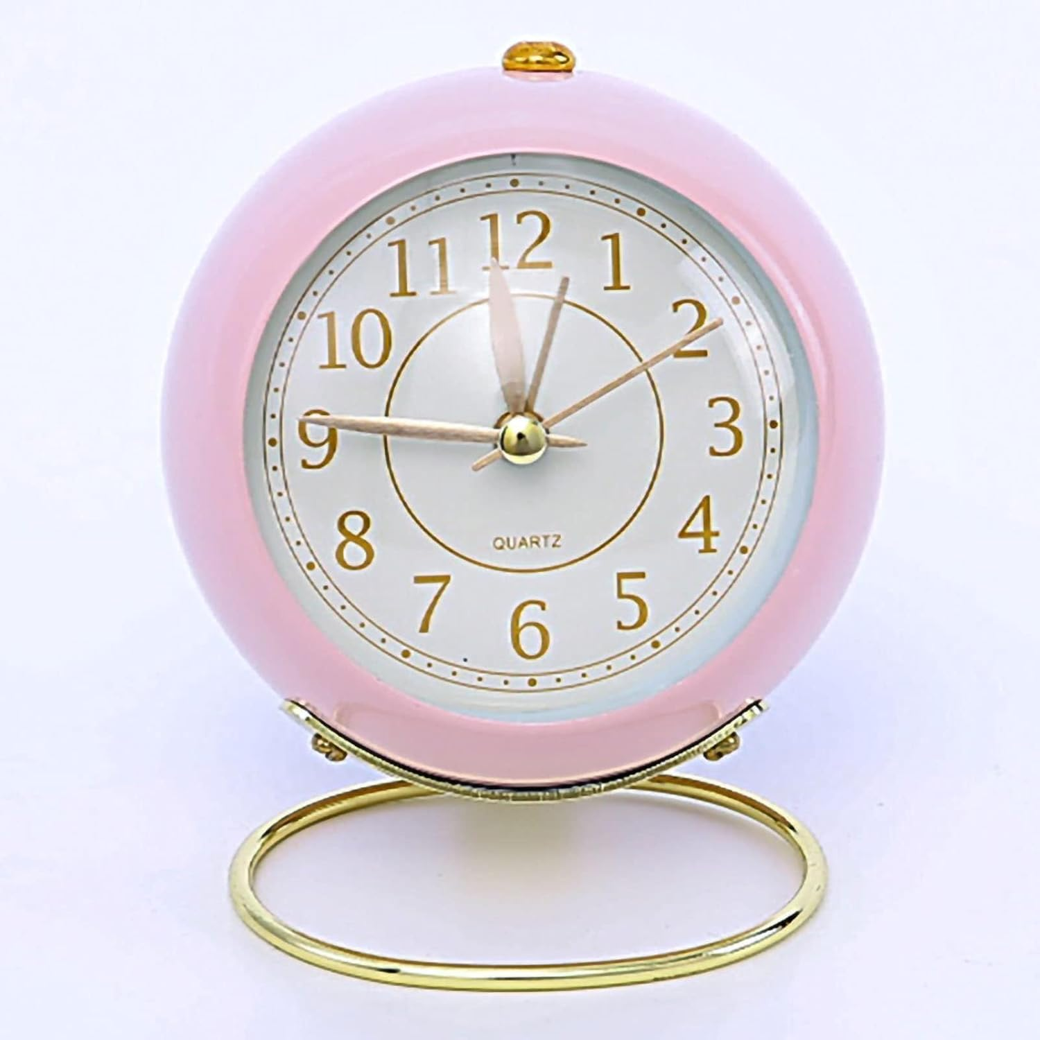 Ein runder, pastellrosa Wecker auf einem goldenen Ständer, mit silbernen Zeigern.
