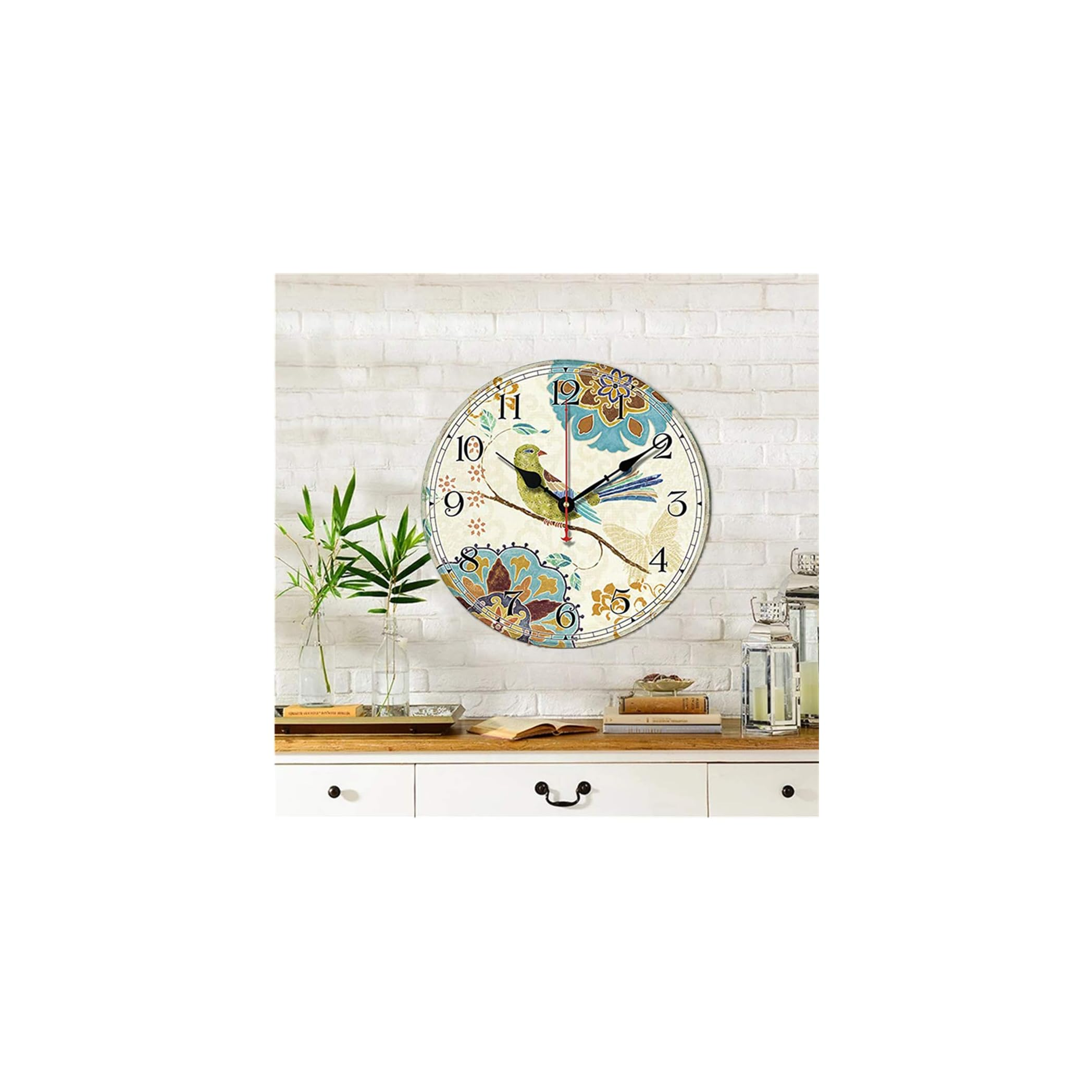 Eine Wanduhr mit Vogelmotiv und Blumen, auf weißer Ziegelwand.