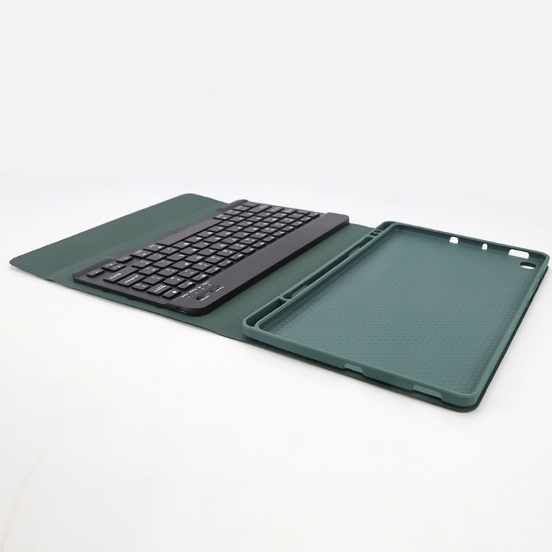 Una tastiera nera giace su una custodia verde per tablet. La custodia è aperta, rivelando l'interno.