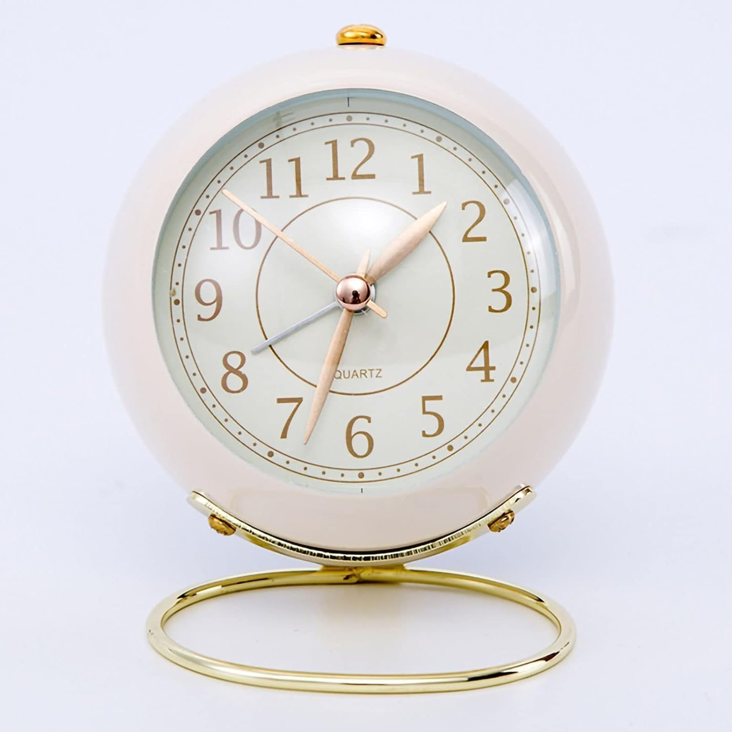 Eine cremefarbene runde Weckeruhr mit goldenem Ständer und Zeigern.