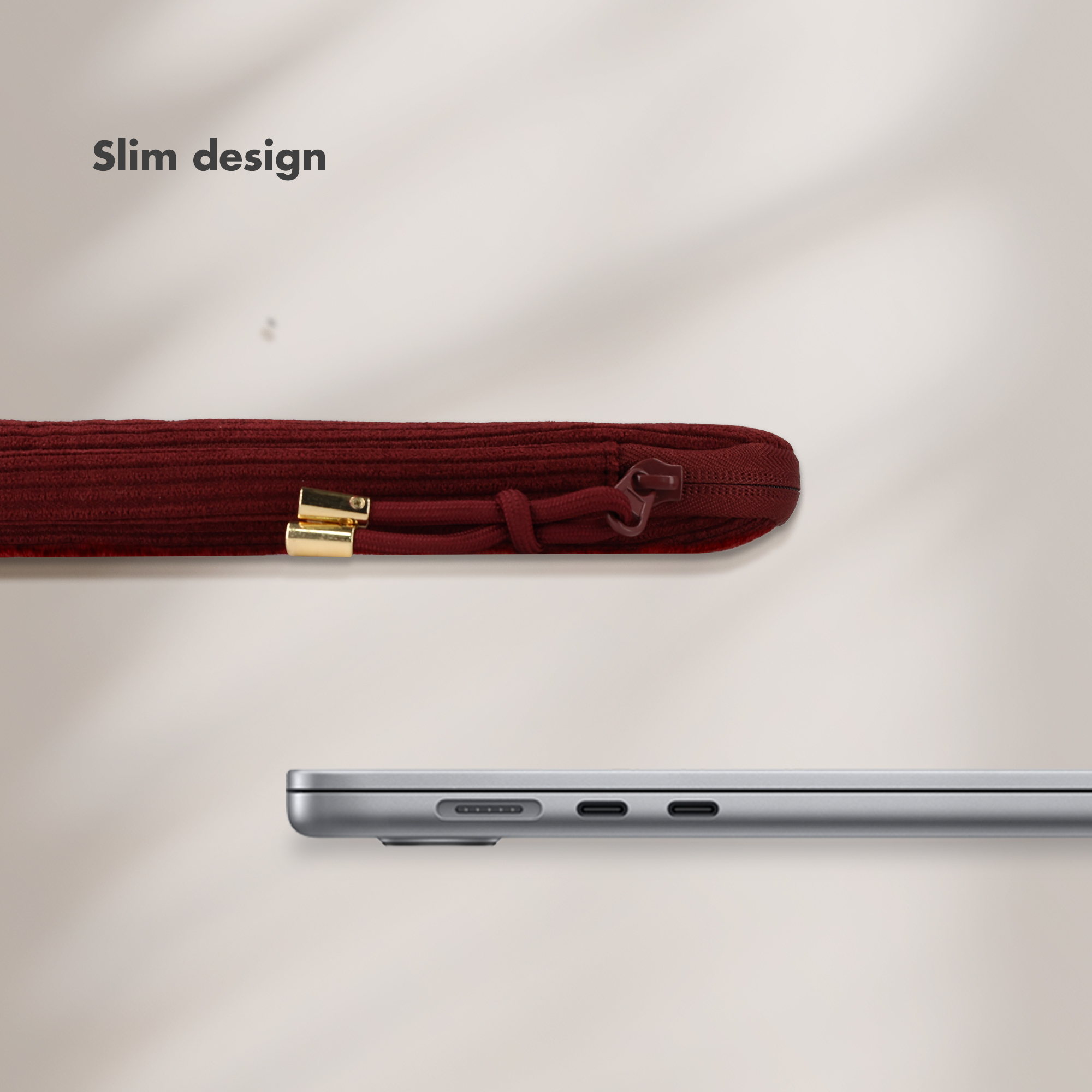 Ein dunkelrotes Etui mit Reißverschluss neben einem silbernen Laptop.