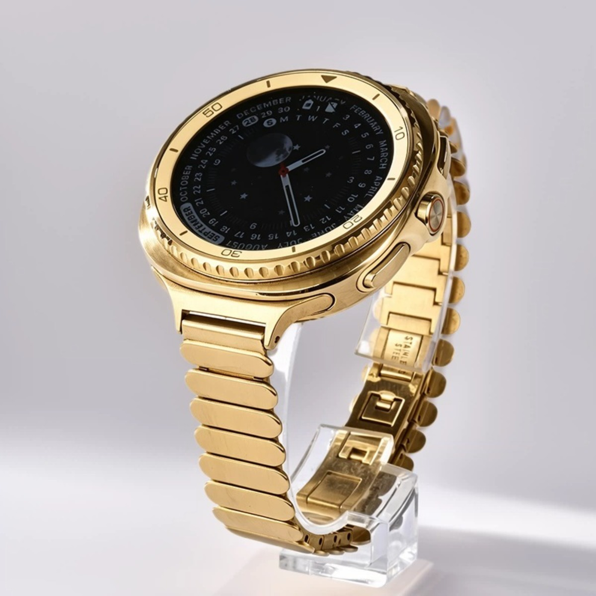 Goldene Smartwatch mit Metallarmband und Kalenderanzeige auf dem Zifferblatt.
