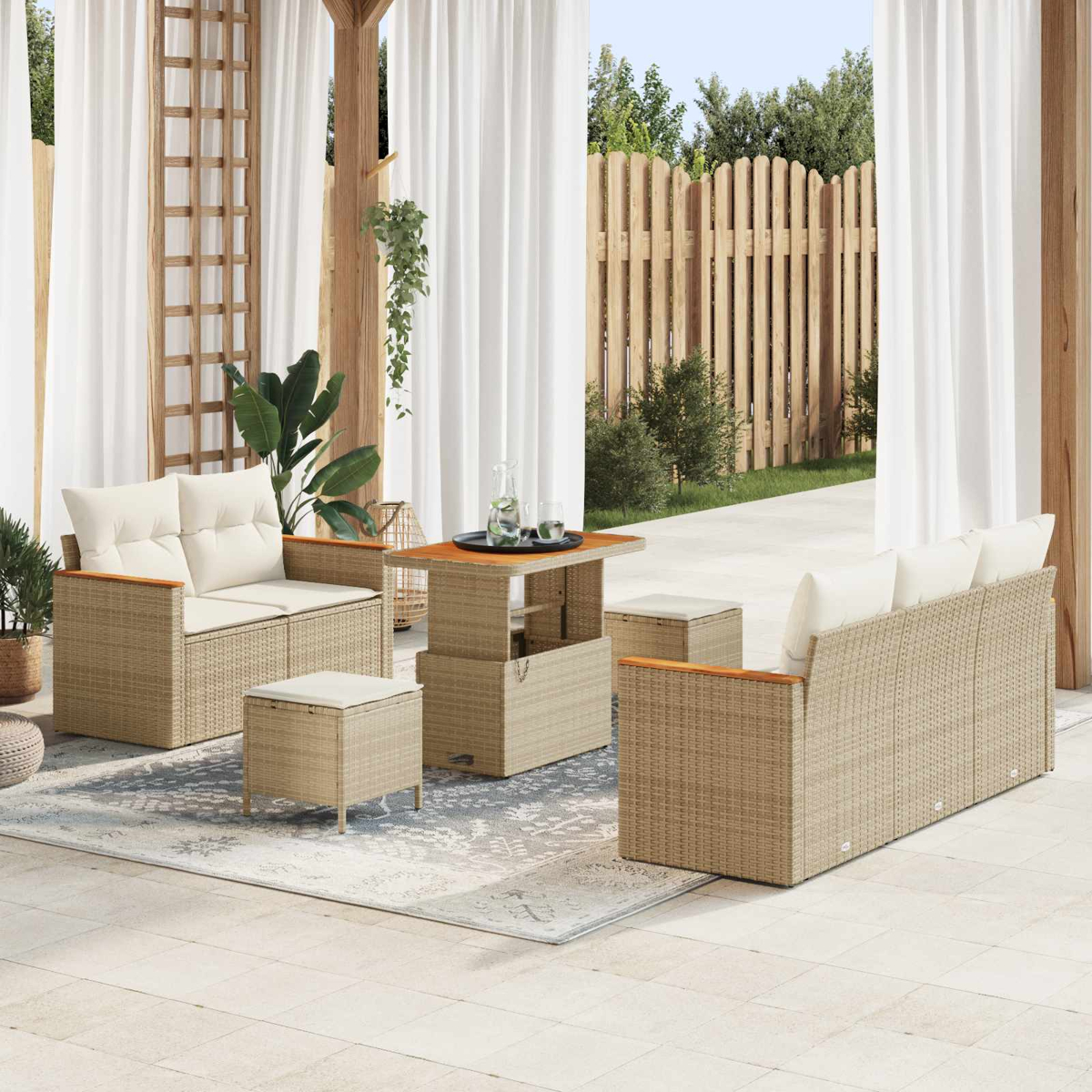 Wicker-Gartenmöbel mit weißen Kissen auf einer Terrasse, mit Holzzaun im Hintergrund.