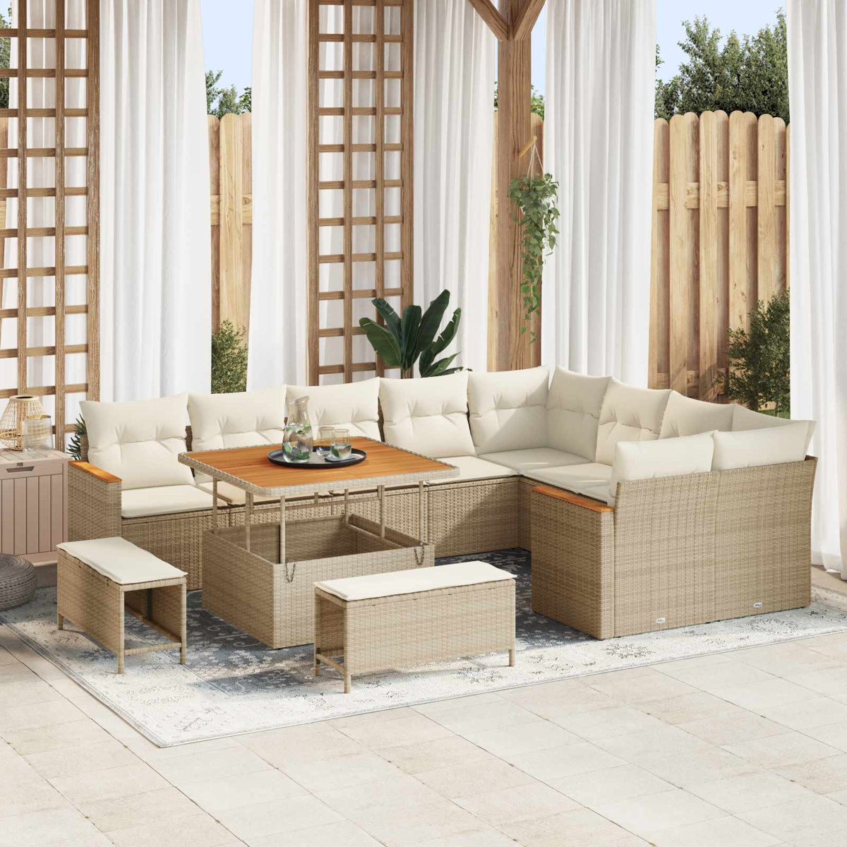 Beiger Rattan-Loungeset mit Tisch, Hockern und weißen Kissen auf einem Teppich.