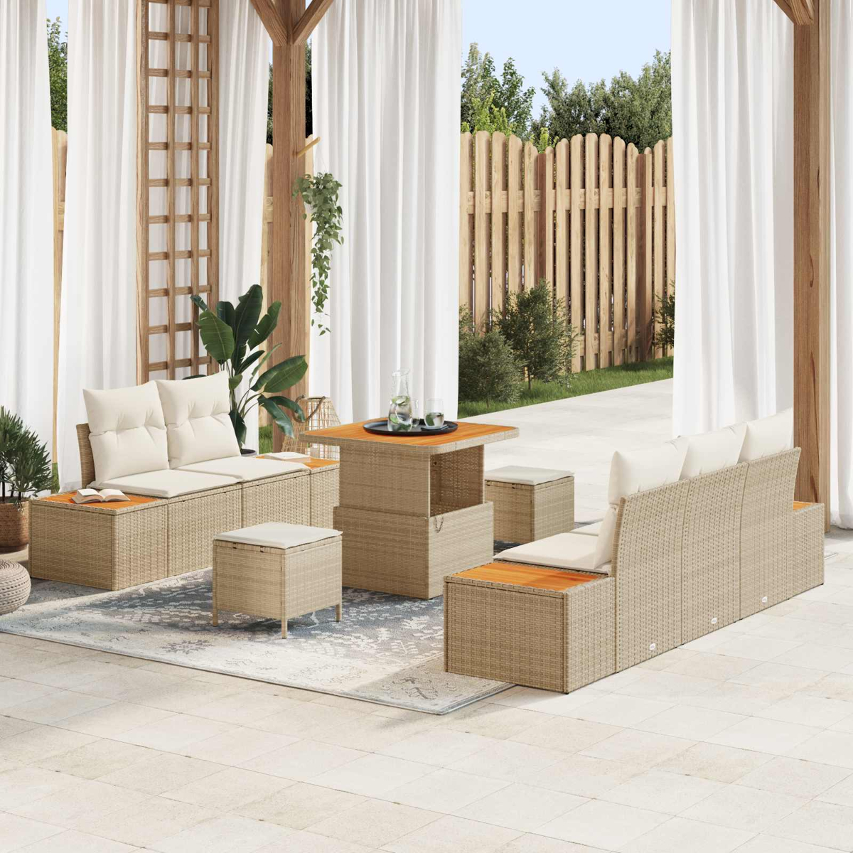 Ein beiger Rattansitzbereich mit Tisch, Kissen und Vorhängen im Freien.