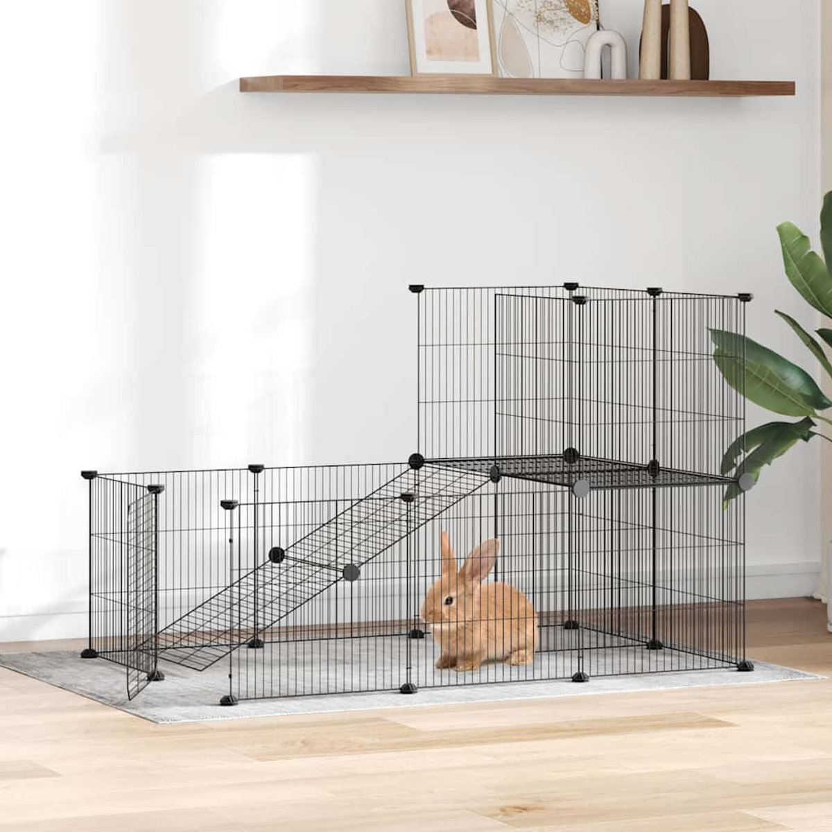 Ein braunes Kaninchen sitzt in einem schwarzen Drahtkäfig mit Rampen und Ebenen.